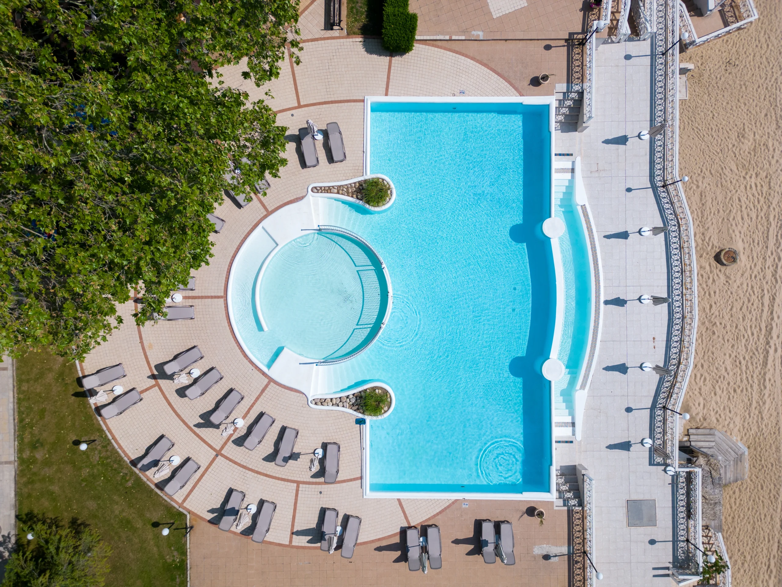 luxury Hamptons custom swimming pool complex with lounge chairs and sandy area by Hamptons Luxury Design + Construction
