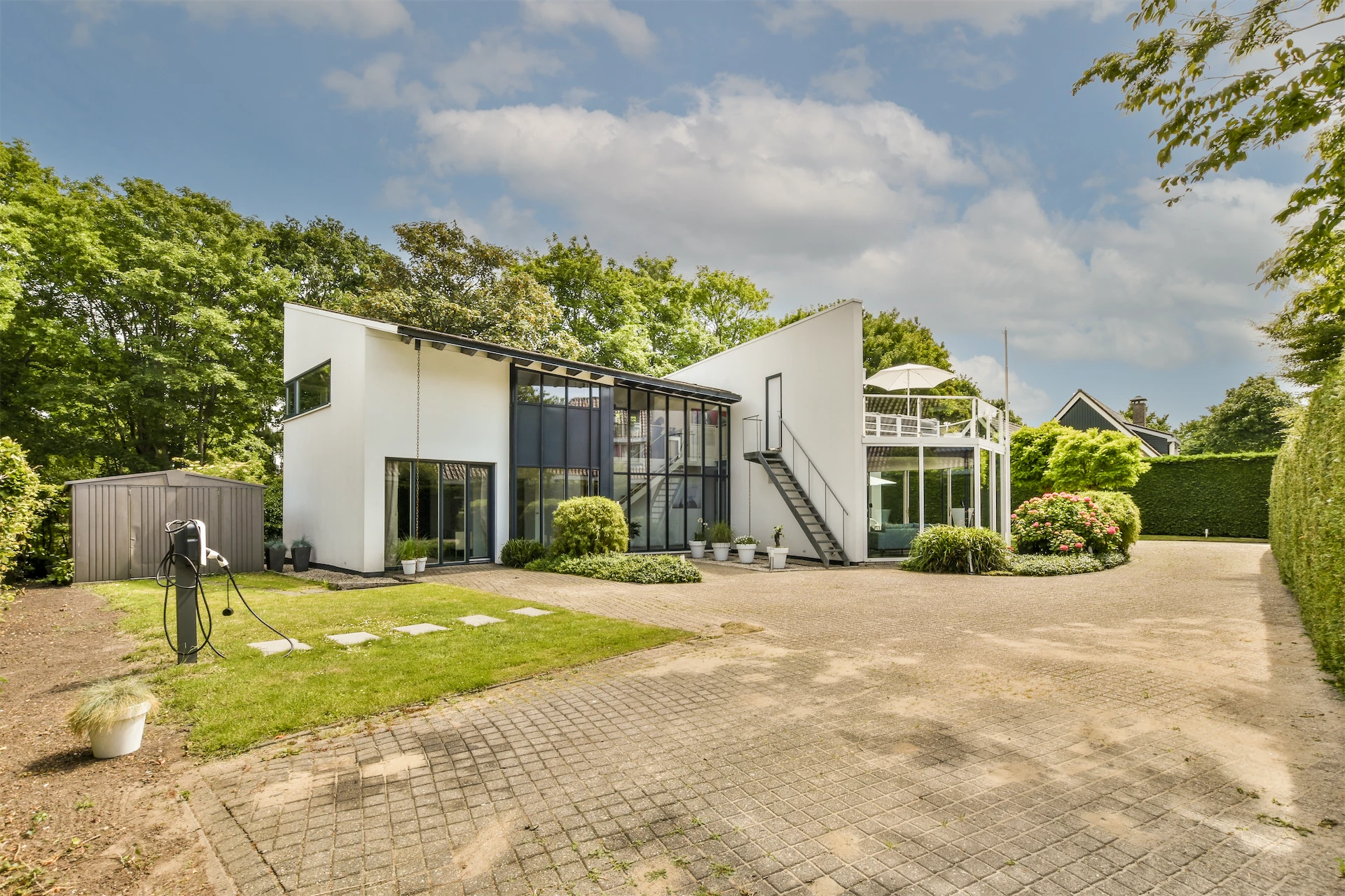 Contemporary two-story home with glass façade and trees