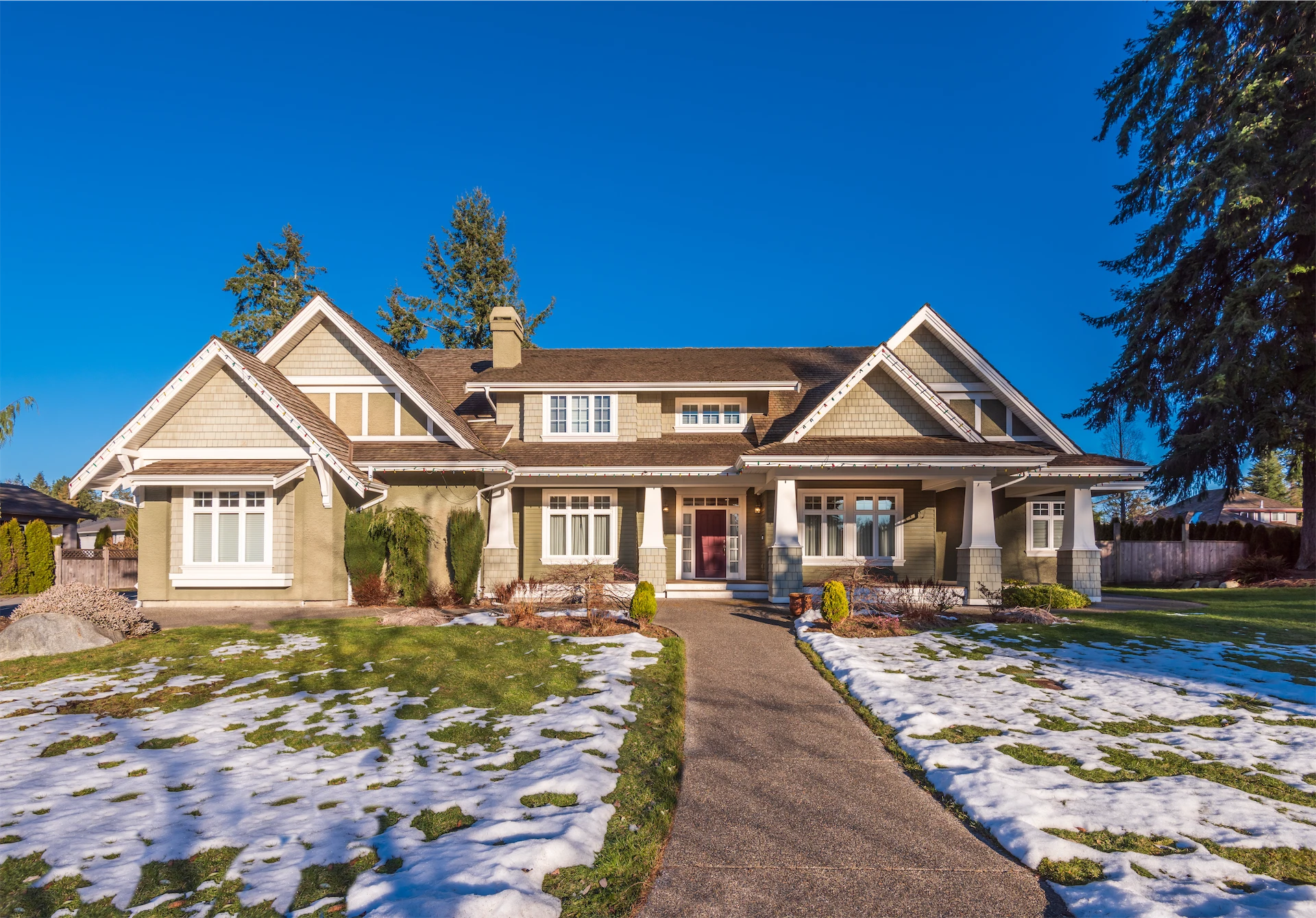 Spacious suburban house with front yard and melting snow