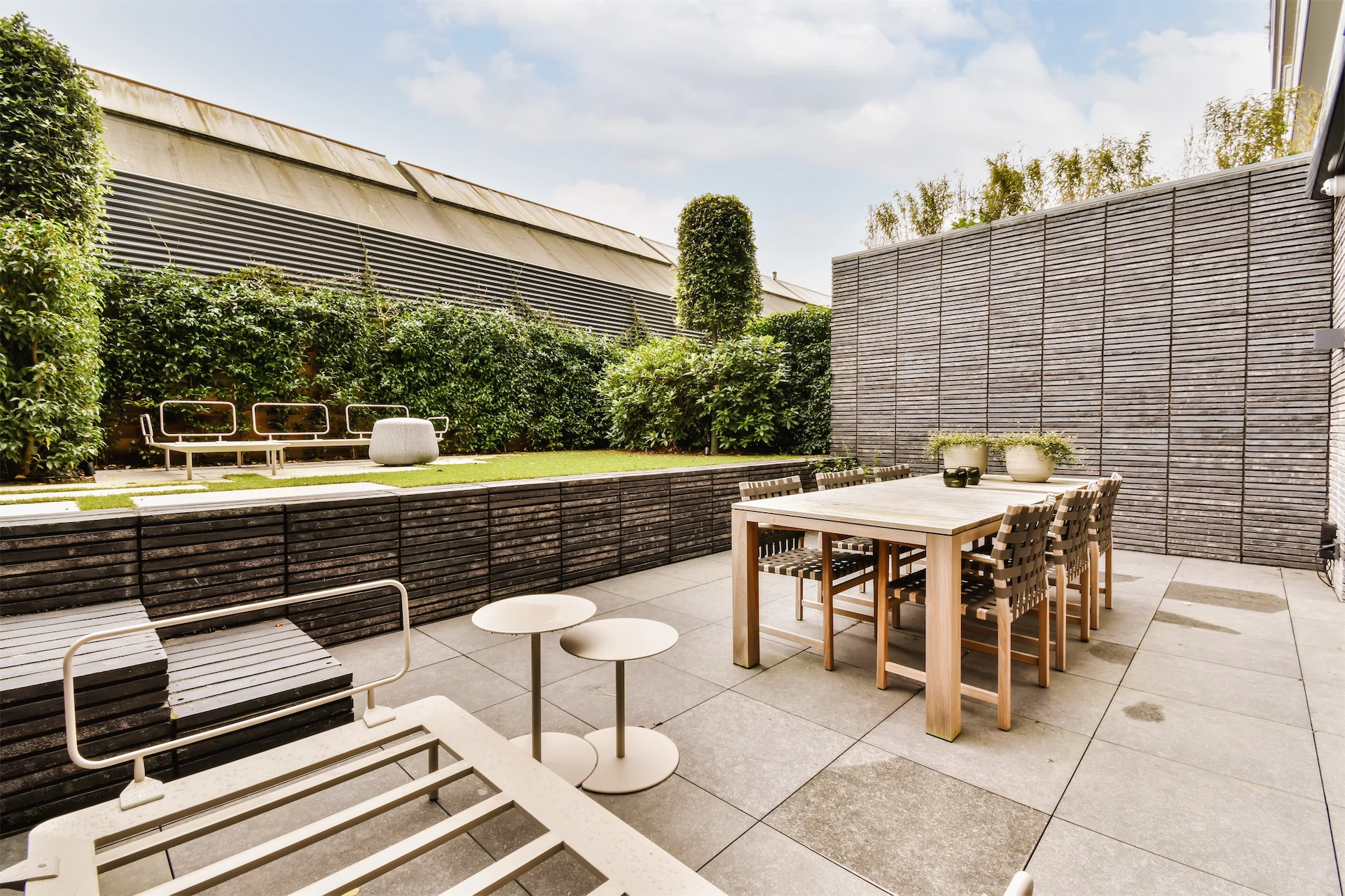 Modern courtyard patio with dining table and fresh lawn
