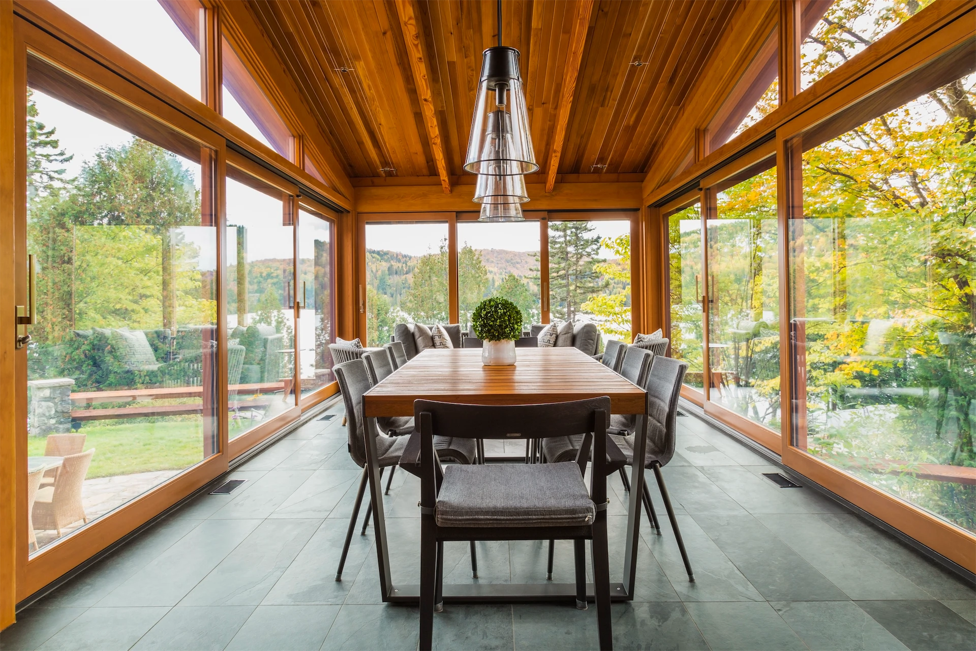 Completed home addition with a spacious dining area, warm wood finishes, and large windows overlooking the landscape