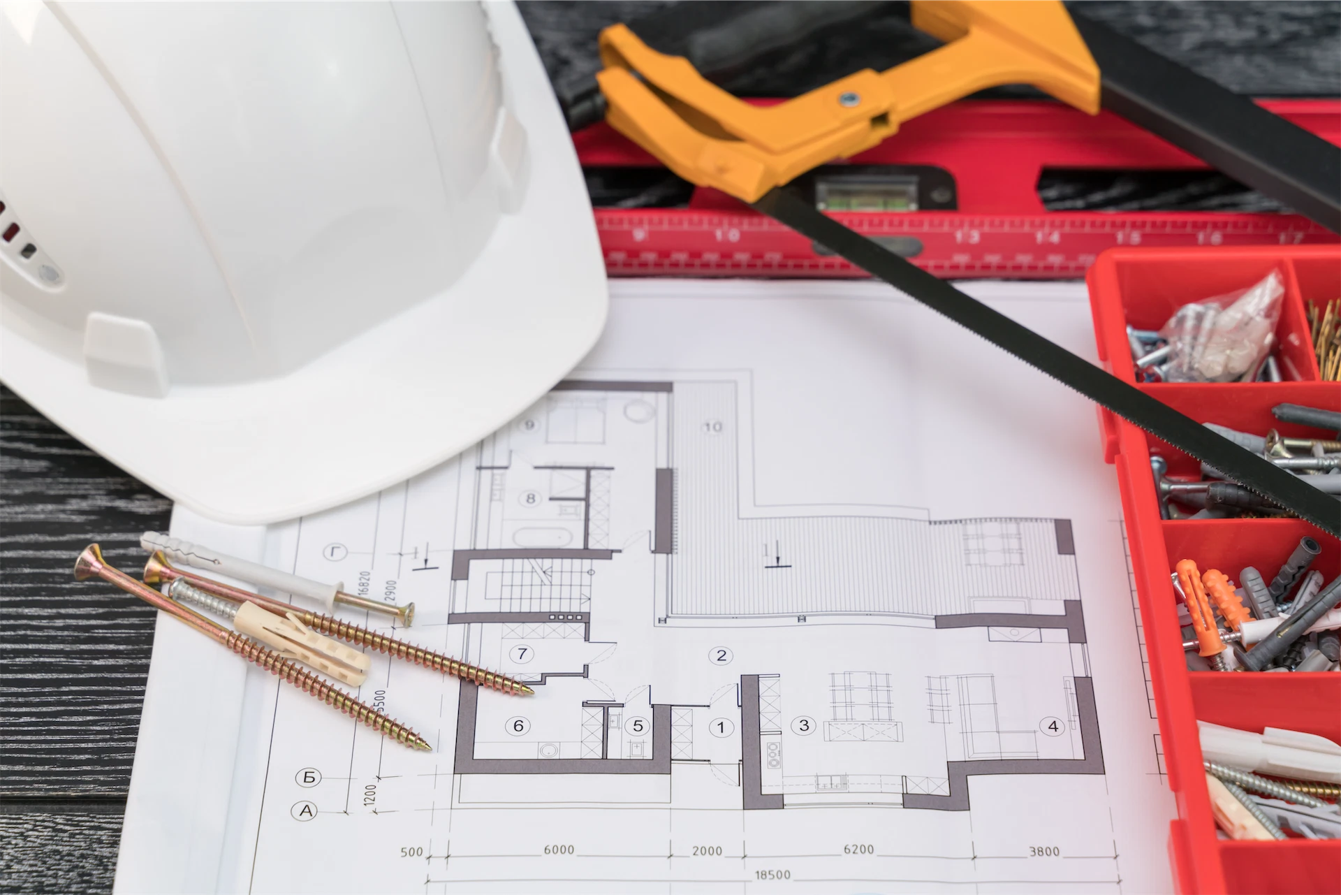 Construction blueprints, hard hat, and building tools representing the planning and construction process of a custom home builder