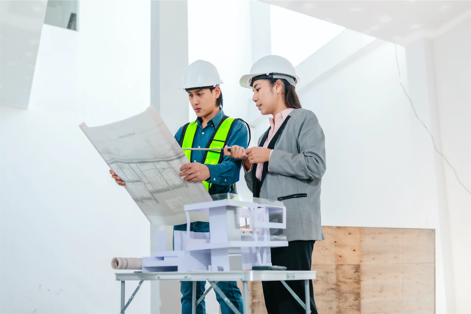 Architects reviewing construction blueprints and building plans during the preconstruction planning phase