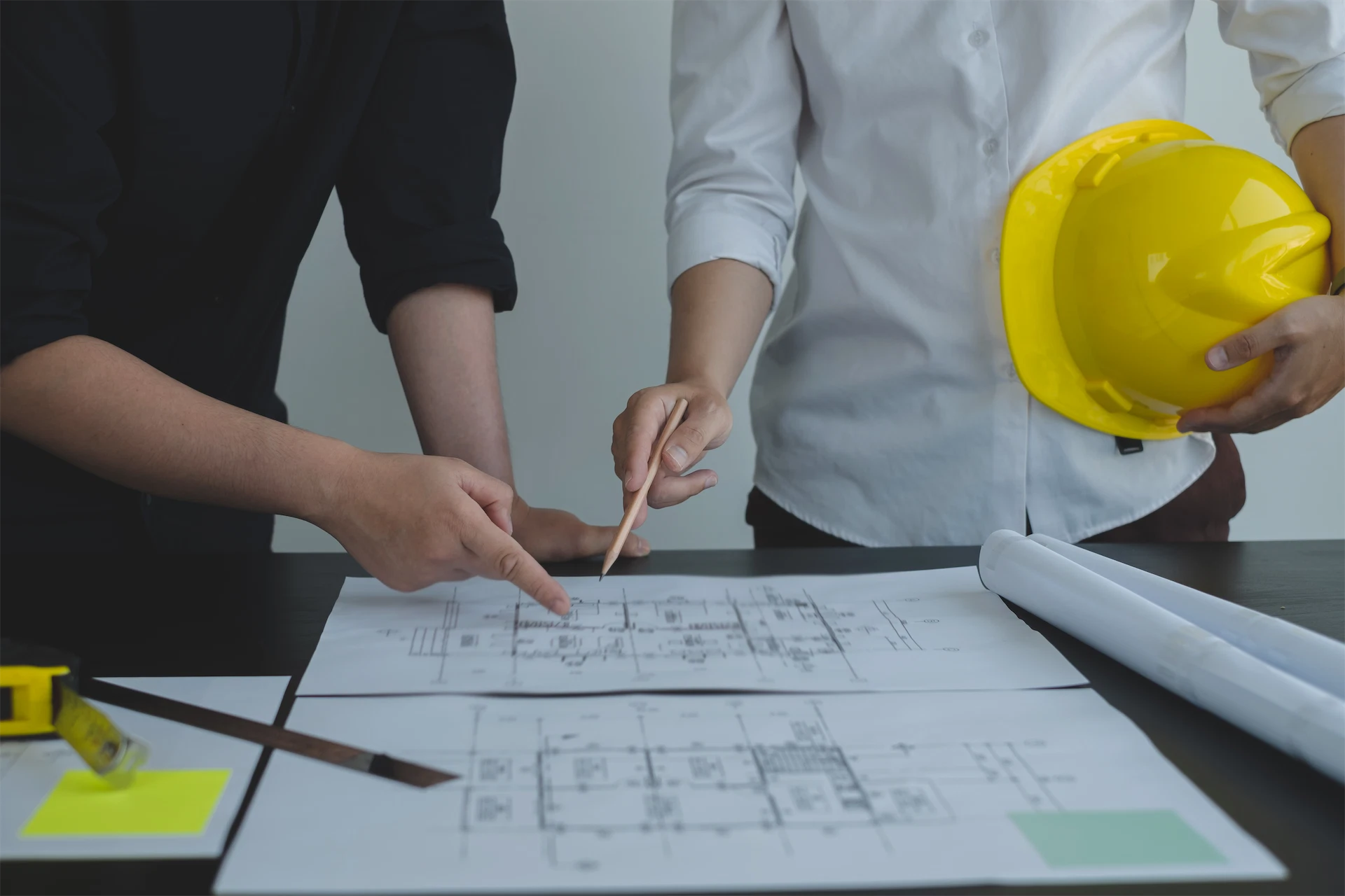 Construction professionals reviewing architectural drawings during the preconstruction design and planning process